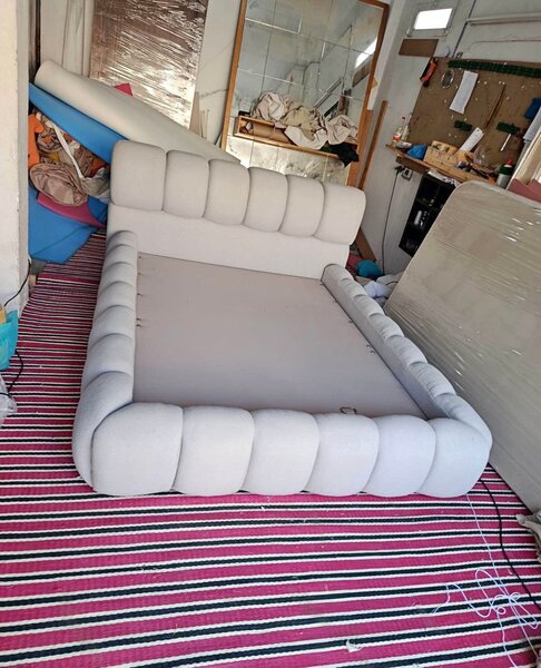 Lit capitonné beige avec tête de lit