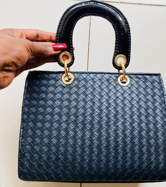 Women's tote bag in black with a braided design, lacquered handles and gold hardware