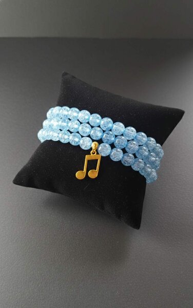 Bracelet perlé bleu avec note de musique dorée