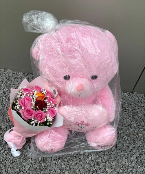Ours en peluche rose avec bouquet de fleurs
