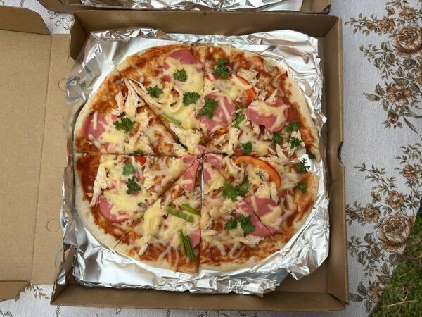 Pizza à base de tomates accompagné de saucisses