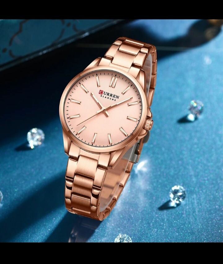 Ladies curren watch with a pink face and metal starps.