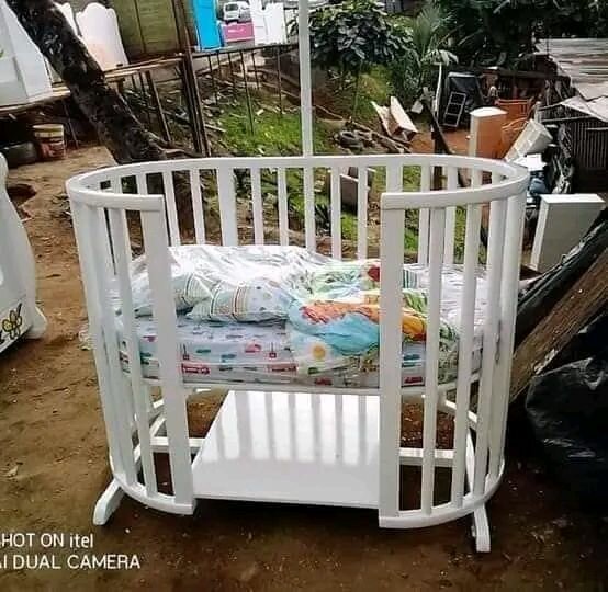 Lit bébé blanc avec balustrades et moustiquaire