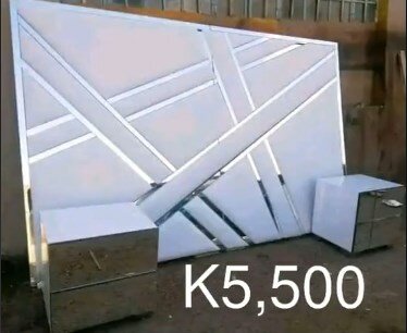 The headboard of the bed is soft, white with silver