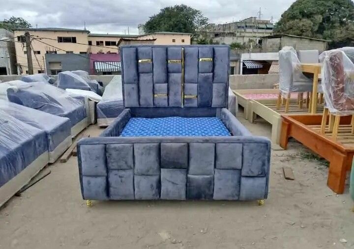 Lit gris avec tête de lit capitonnée