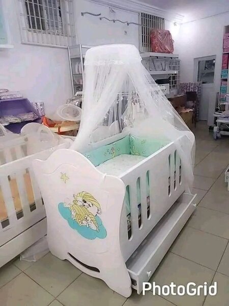 Lit bébé blanc avec balustrades et moustiquaire