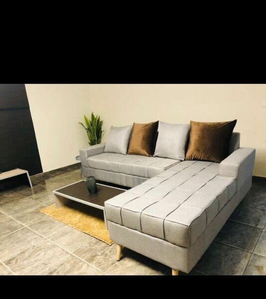 Canapé d'angle gris clair avec ottomane