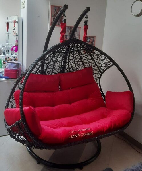 Fauteuil suspendu en rotin avec coussins rouges