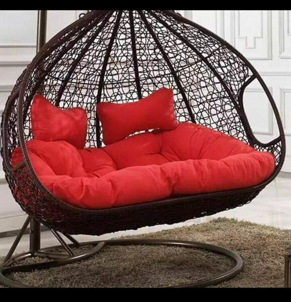 Fauteuil suspendu en rotin avec coussins rouges