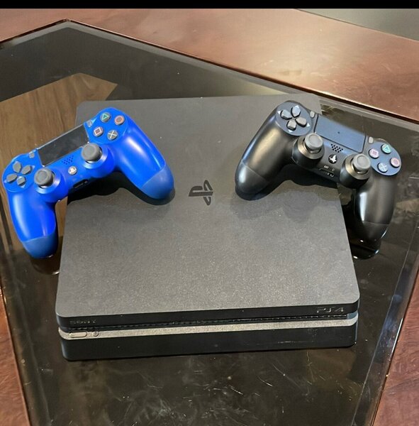 PS4 SLIM QUASI NEUVE AVEC 2 MANETTES ET 2 CD