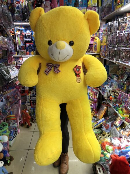 Gros ours en peluche jaune avec nœud