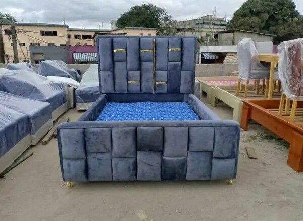 Lit gris avec tête de lit capitonnée