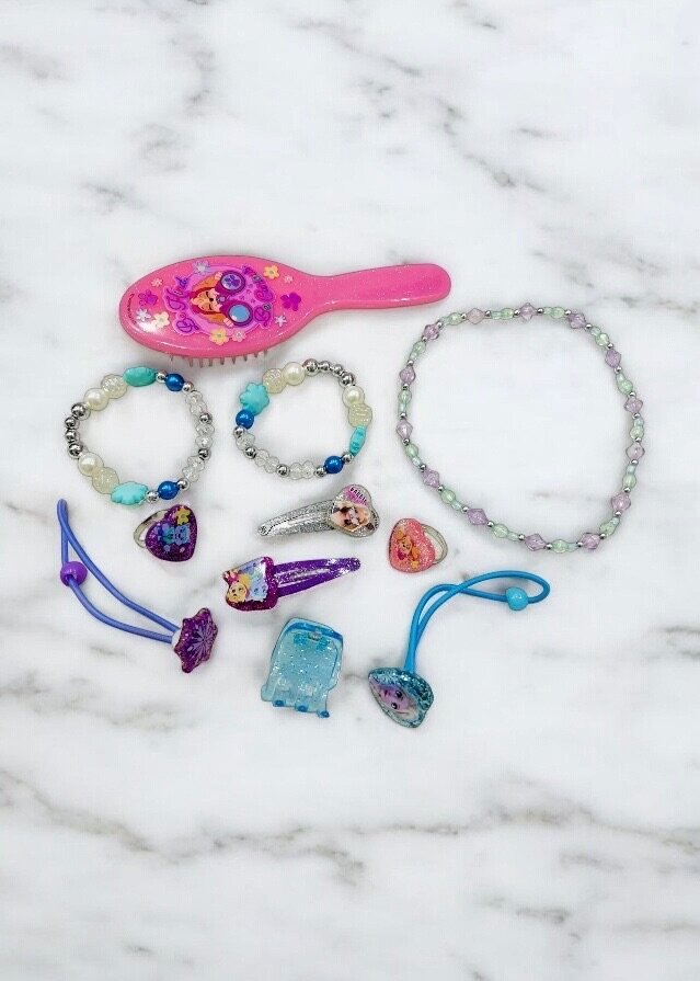 Pink bag with hair accessories and jewelry for kids.