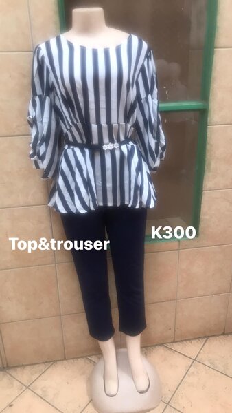 A woman's suit, black trousers and a striped blouse.