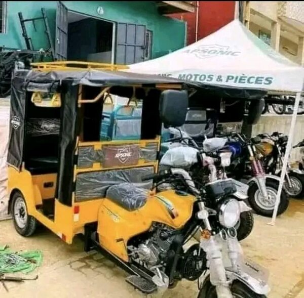 Tricycle motorisé jaune avec bâche de protection