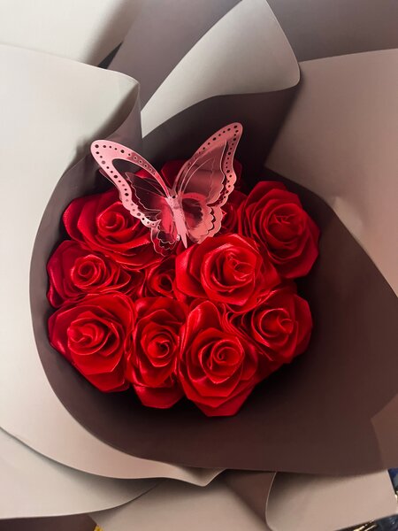 Fleurs artificielles roses rouges avec papillon